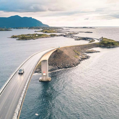 Car driving across the atlantic road in Norway at sunset