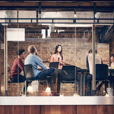 Group of people having a business meeting in modern office with brick walls