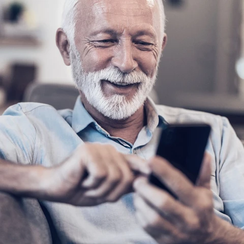 Senior man smiling at phone