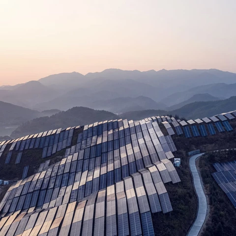 Aerial view of the solar power plant on the top of the mountain at sunset