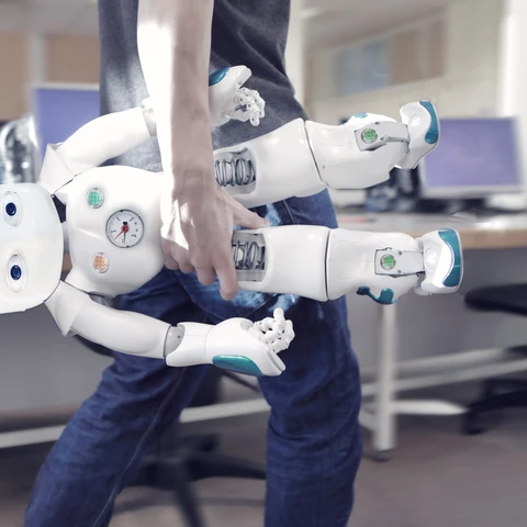 man carrying robot in office