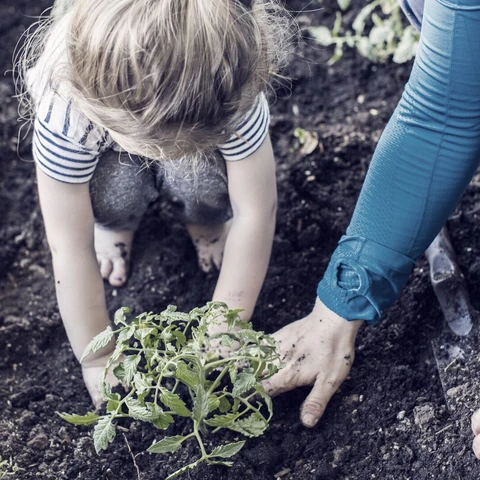Mother teaching gardening to daughter