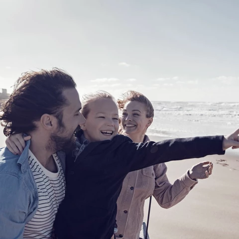 Happy family laughing on the beach
