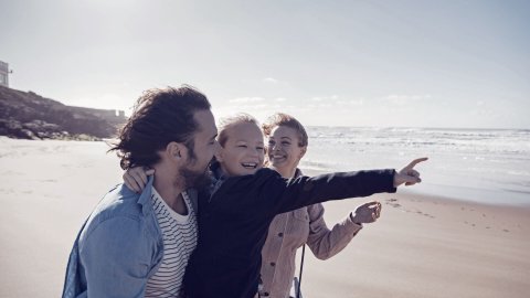 Happy family laughing on the beach