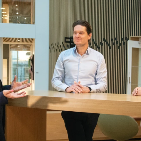Mukadas Khan, Kjetil Olsen og Derya Incedursun står ved et bord og diskuterer