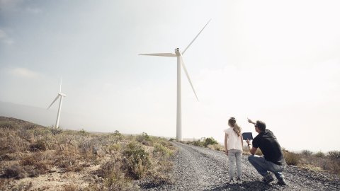 Man with young girl pointing at windmills