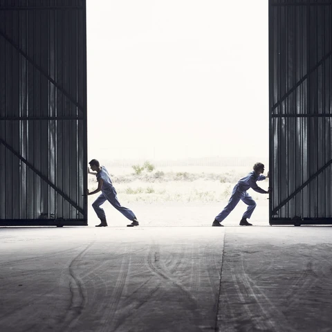 Teamwork pushing barndoors open