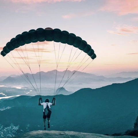 Paraglider taking off from mountain