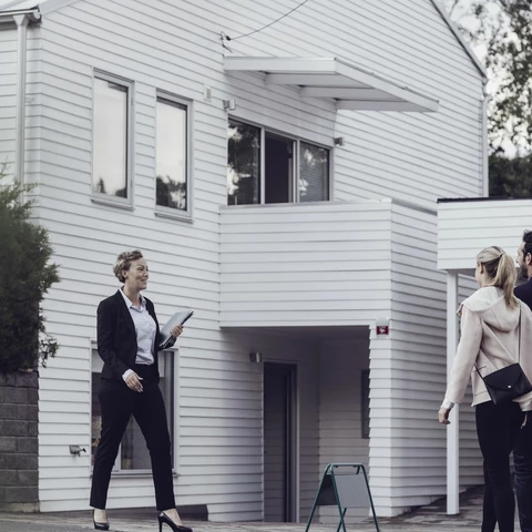 Smiling real estate professional talking to couple