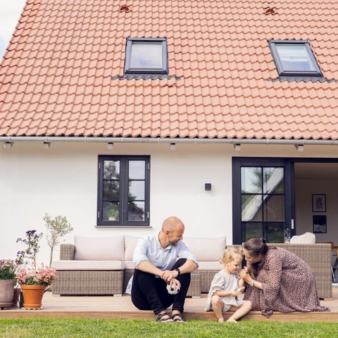 Parents and child in front of house