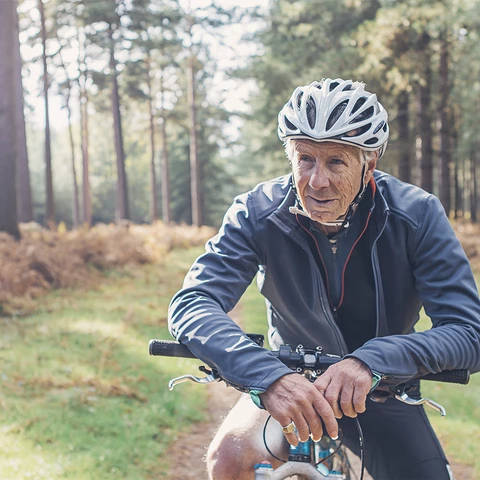 Elderly man on bicycle in the woods