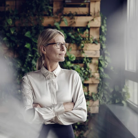 Businesswoman in green office looking out of window