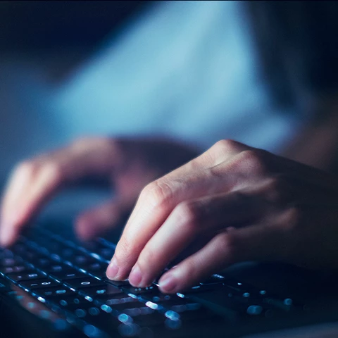 Closeup of woman working late with laptop in the dark