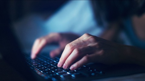 Closeup of woman working late with laptop in the dark