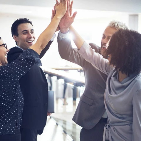 Cheerful office team giving high five.jpg