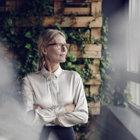 Businesswoman in green office looking out of window1920x1080.jpg