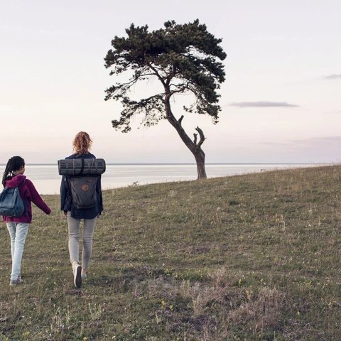 Mother and daughter hiking on field