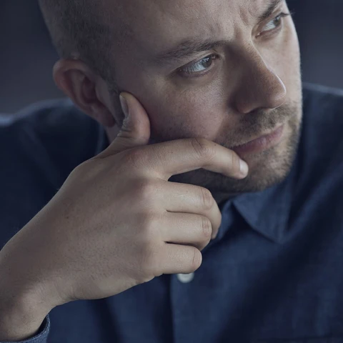 Businessman sitting in conference room, looking thoughtful