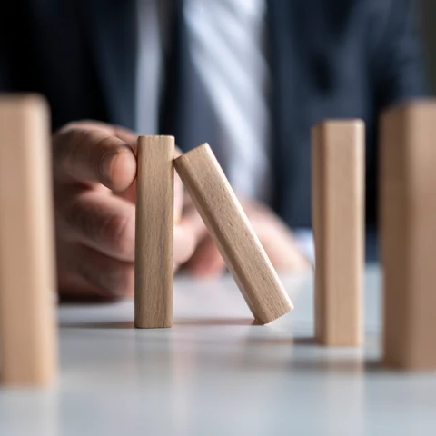 man stopping domino effect