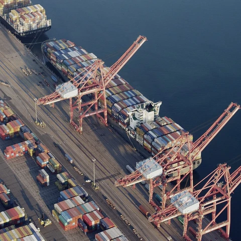 Containers and cranes in industrial shipyard