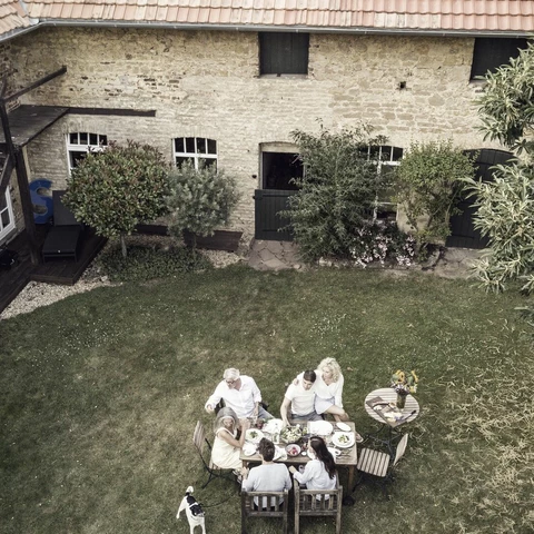 Family eating together in the garden in summer