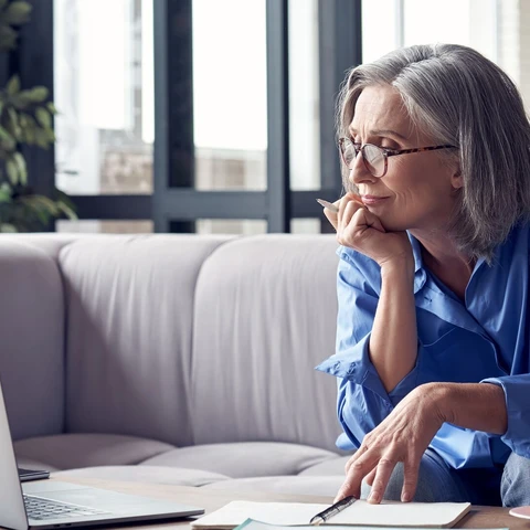 Mature woman watching online webinar on laptop