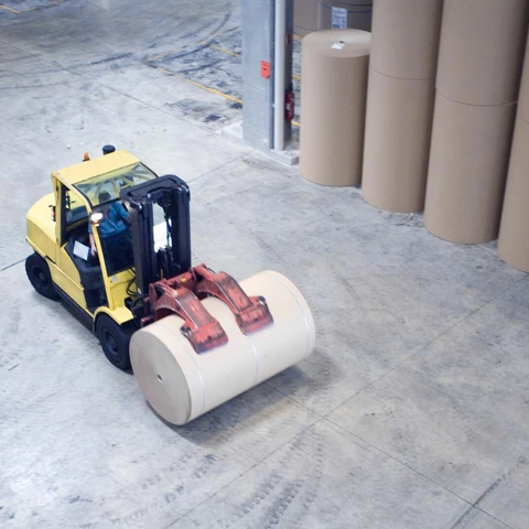 Fork lift picking up roll of paper