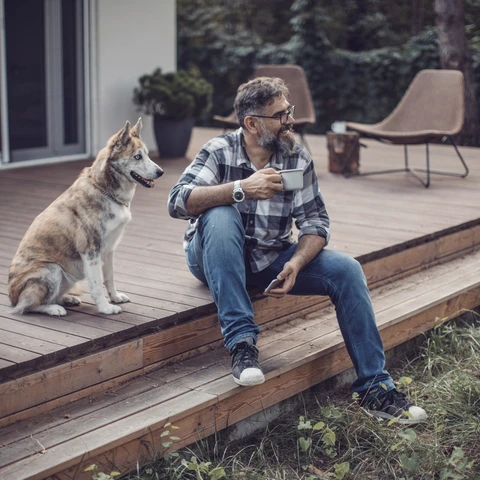 Man sitting on a porch with a dog