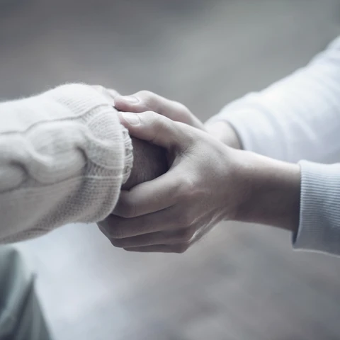 Two persons holding hands