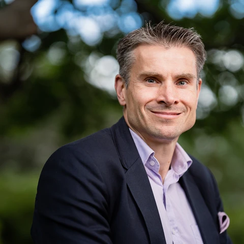 Nordean pääanalyytikko Jan von Gerich on pukeutunut vaaleaan kauluspaitaan ja siniseen pikkutakkiin ja katsoon kameraan taustallaan metsäinen puistomaisema.