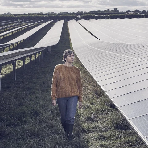 Female farmer walking through solar farm
