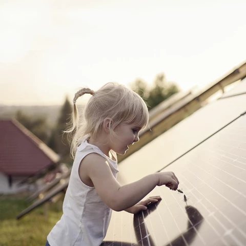 Young girl touching solar panel