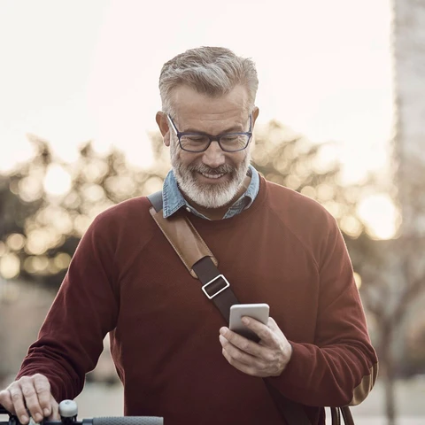 Happy man with mobile phone and bicycle