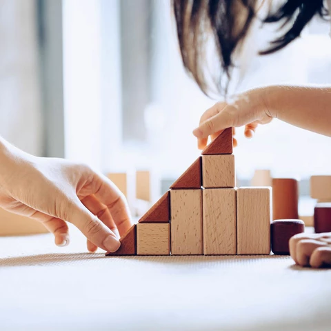 Mother and daughter playing with wooden blocks