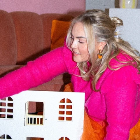 Person playing with a dollhouse