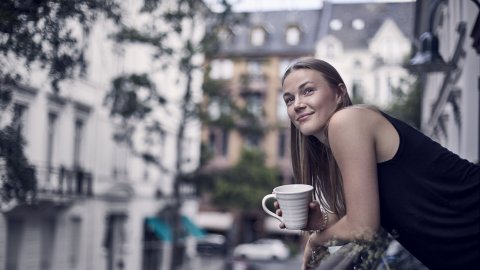 Woman drinking coffee on her balcony