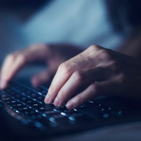 Fingers writing on computer keyboard