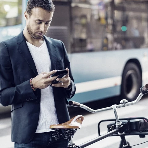 businessman-using-mobile-phone-while-standing-with-bicycle