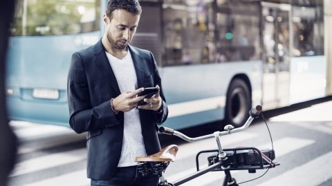businessman-using-mobile-phone-while-standing-with-bicycle
