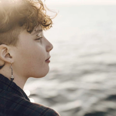 Teenage with piercing looking at sea