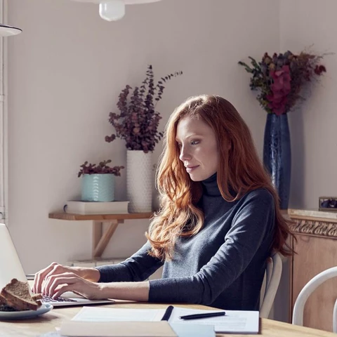 Woman using laptop while working at home