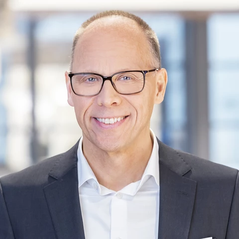 Man with glasses looking into the camera