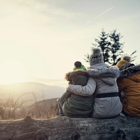 Mother and kids enjoying sunset in the mountains