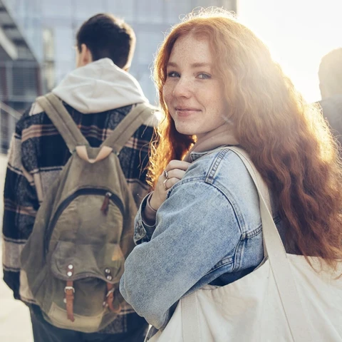 Student walking with friends, looking at camera