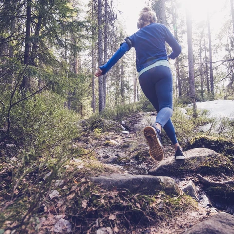 Woman trail runner running in forest