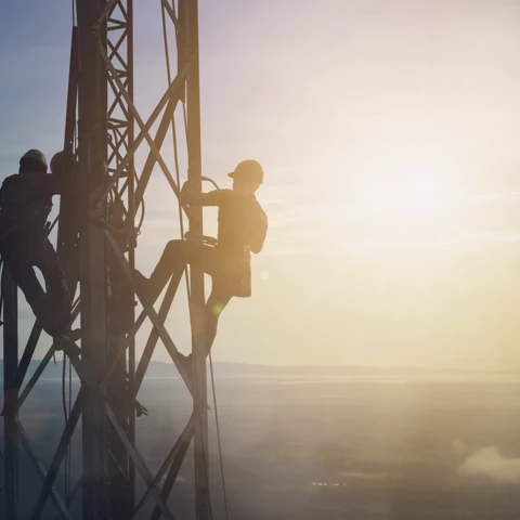 Silhouette electrician work on high ground on electrical grid equipment