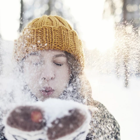 Tjej blåser snö mot kameran