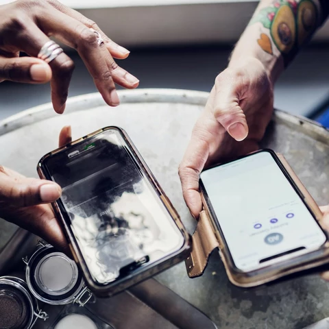 Friends sending money to each other using smart phones