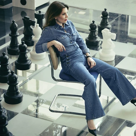 women sitting on a chair on a big chess board