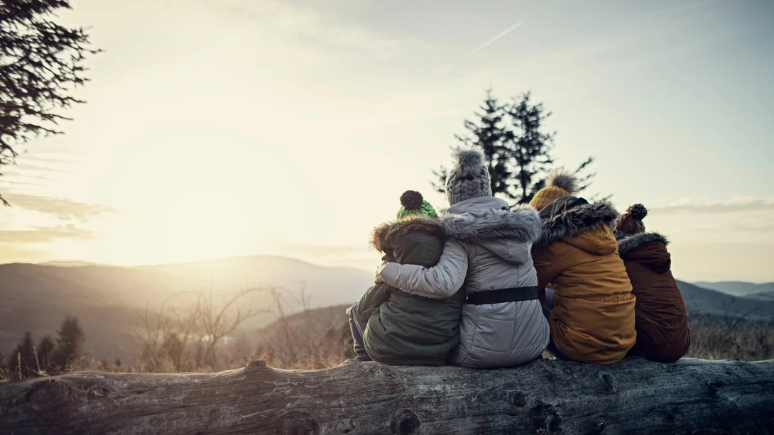 Mother and kids enjoying sunset in the mountains